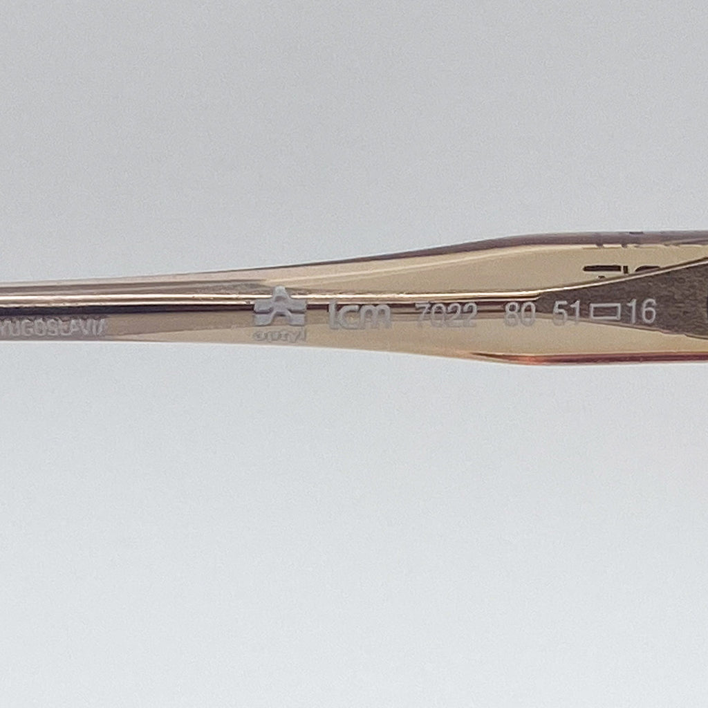 Close-up of an eyeglass temple arm with engraved text on a light gray background