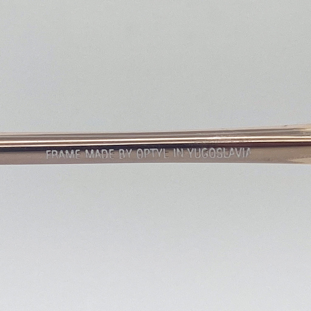 Eyeglass frame with 'Frame made by Optyle in Yugoslavia' engraving on a light gray background