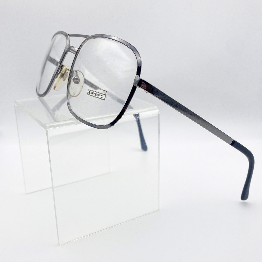 Eyeglasses on a clear stand with a light gray background