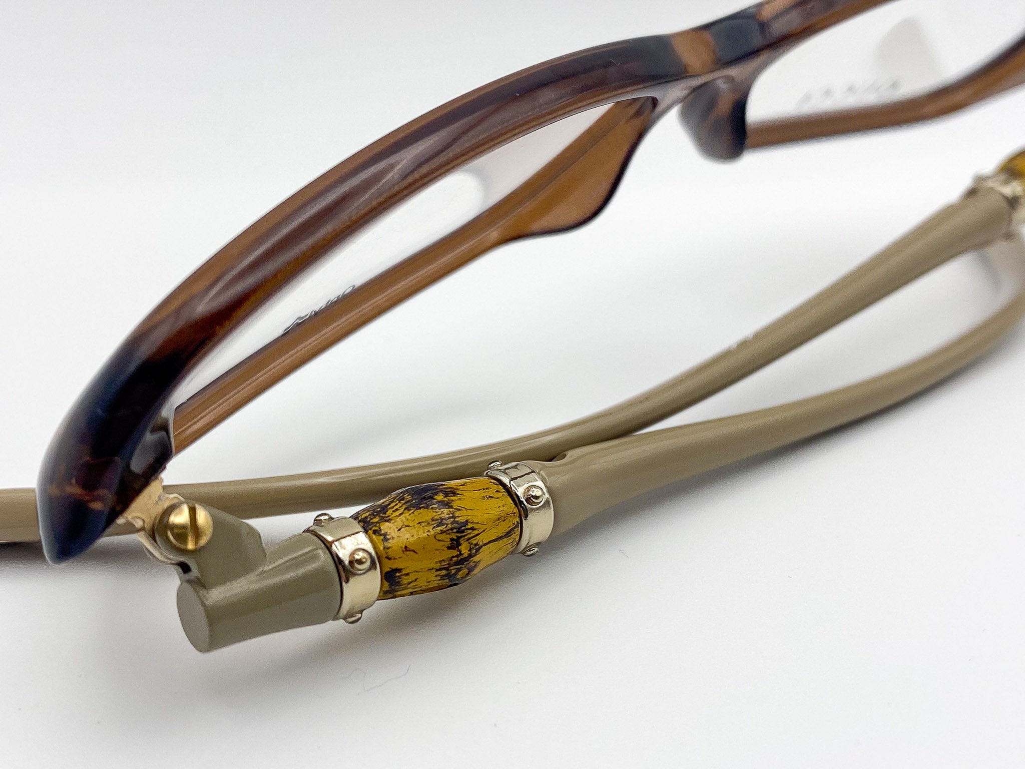 Eyeglasses with tortoiseshell frame and wooden temple tips on a white background