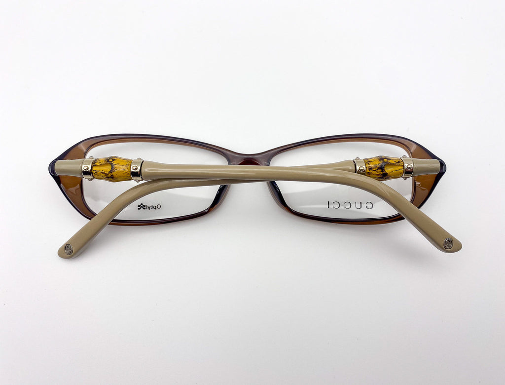 Gucci eyeglasses with brown frame and gold accents on a white background