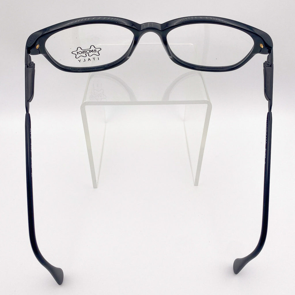 Black eyeglasses on a clear stand against a white background