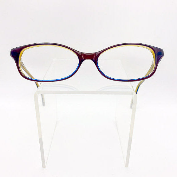 Multicolored eyeglasses on a clear plastic stand against a white background