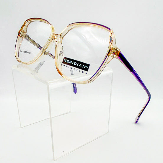 1980s eyeglasses with a colorful frame on a clear stand against a white background