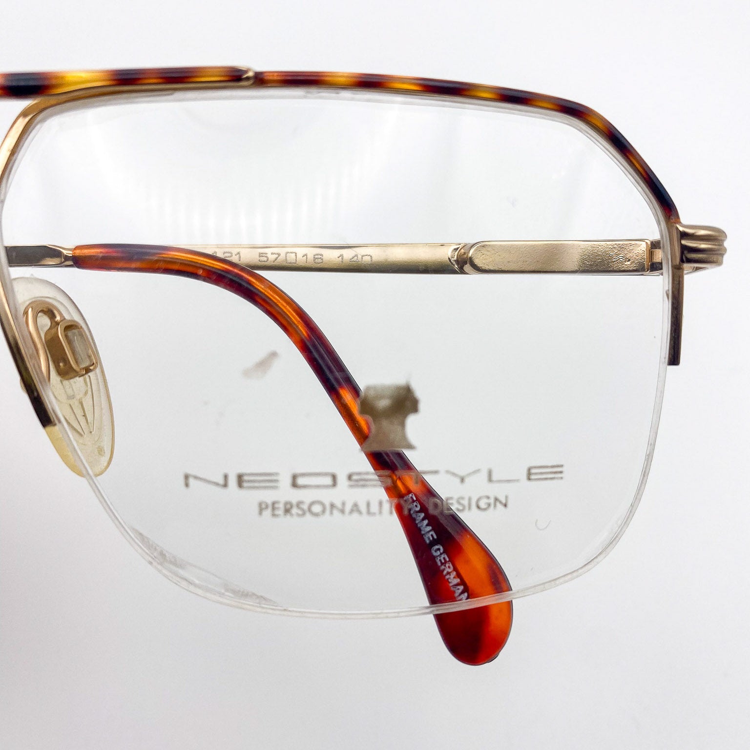 Vintage eyeglasses with tortoiseshell frame and clear lenses on a white background