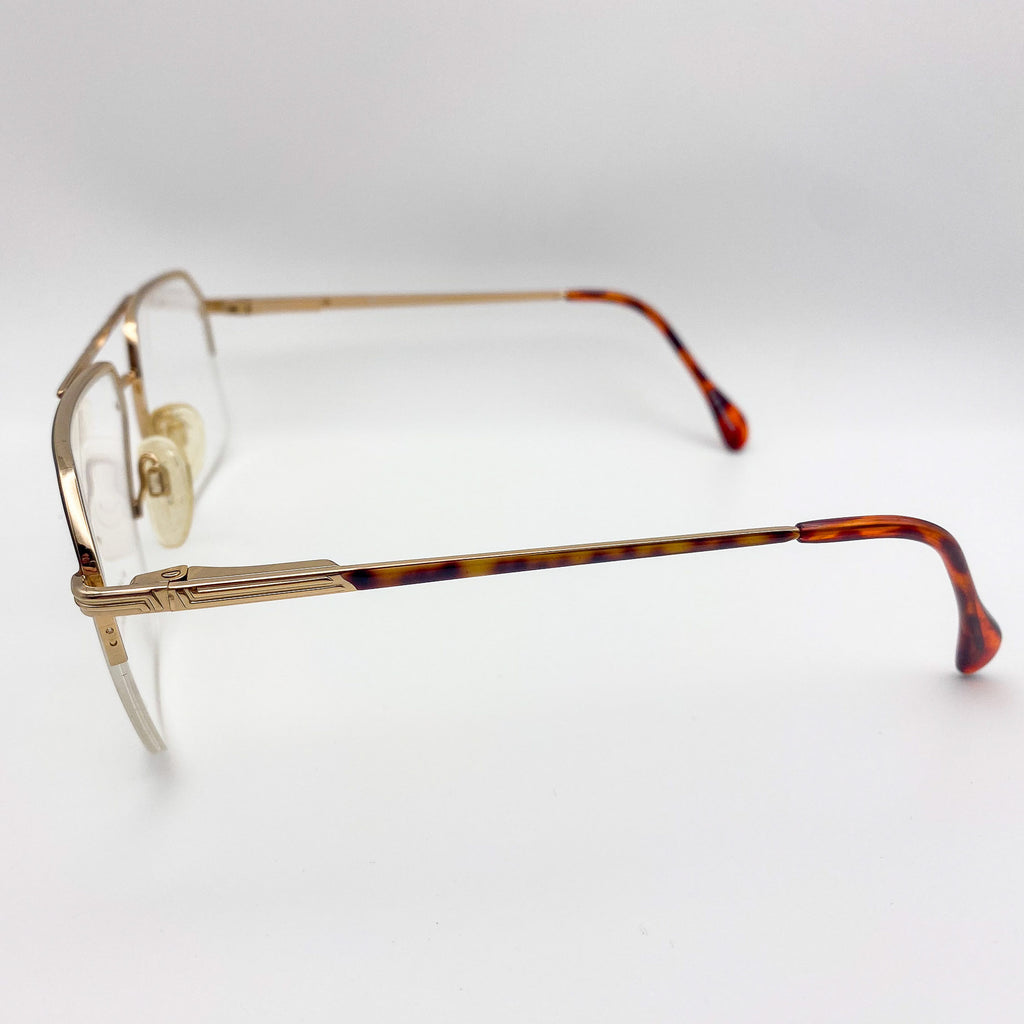 Aviators with a gold frame and tortoiseshell arms on a light gray background