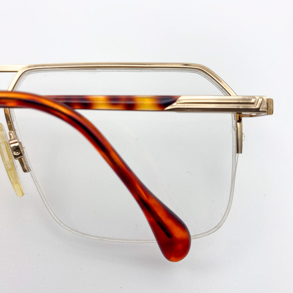 Eyeglasses with gold frame and tortoiseshell arms on a white background