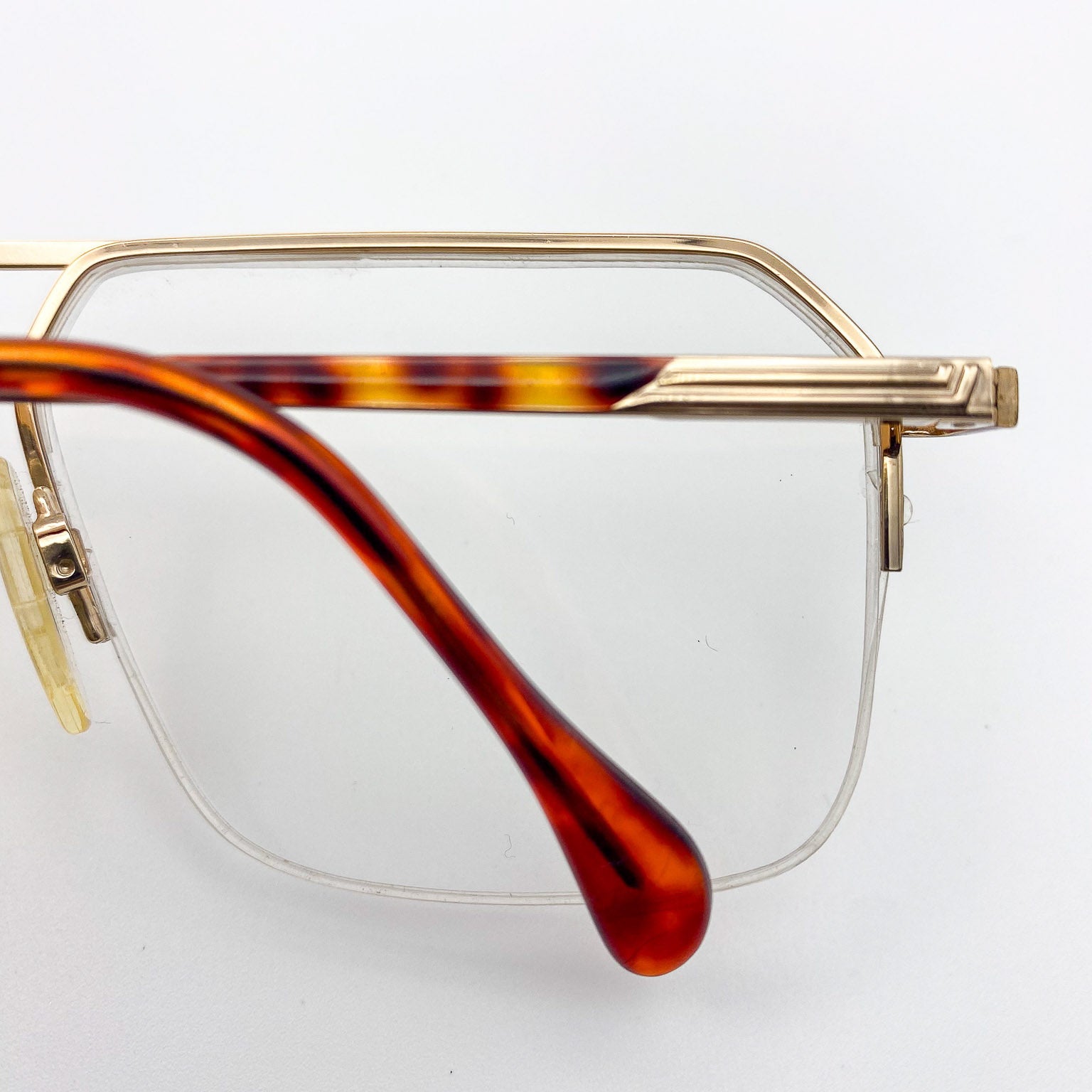 Eyeglasses with gold frame and tortoiseshell arms on a white background