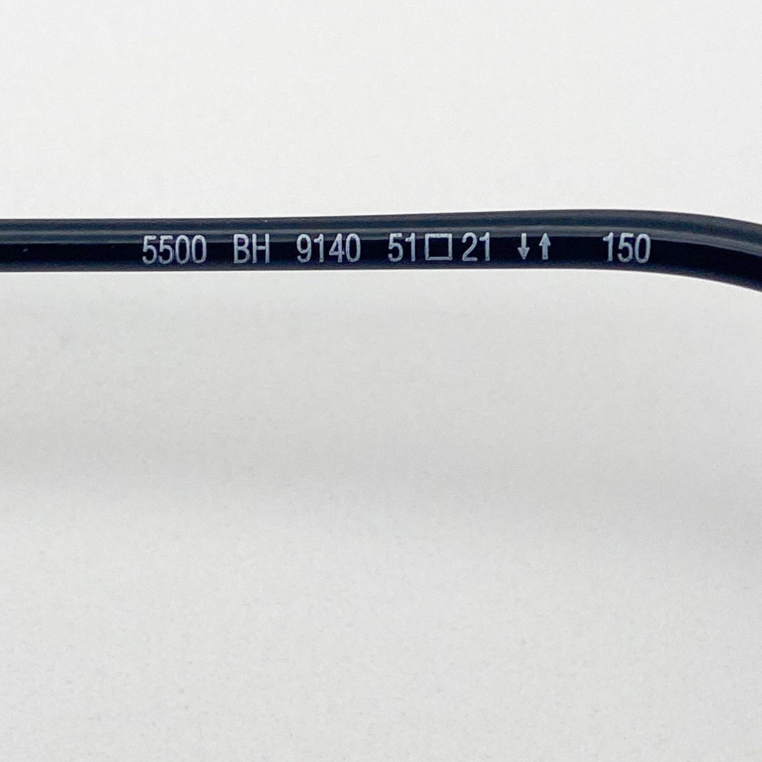 Close-up of a black eyeglass frame with text on a white background
