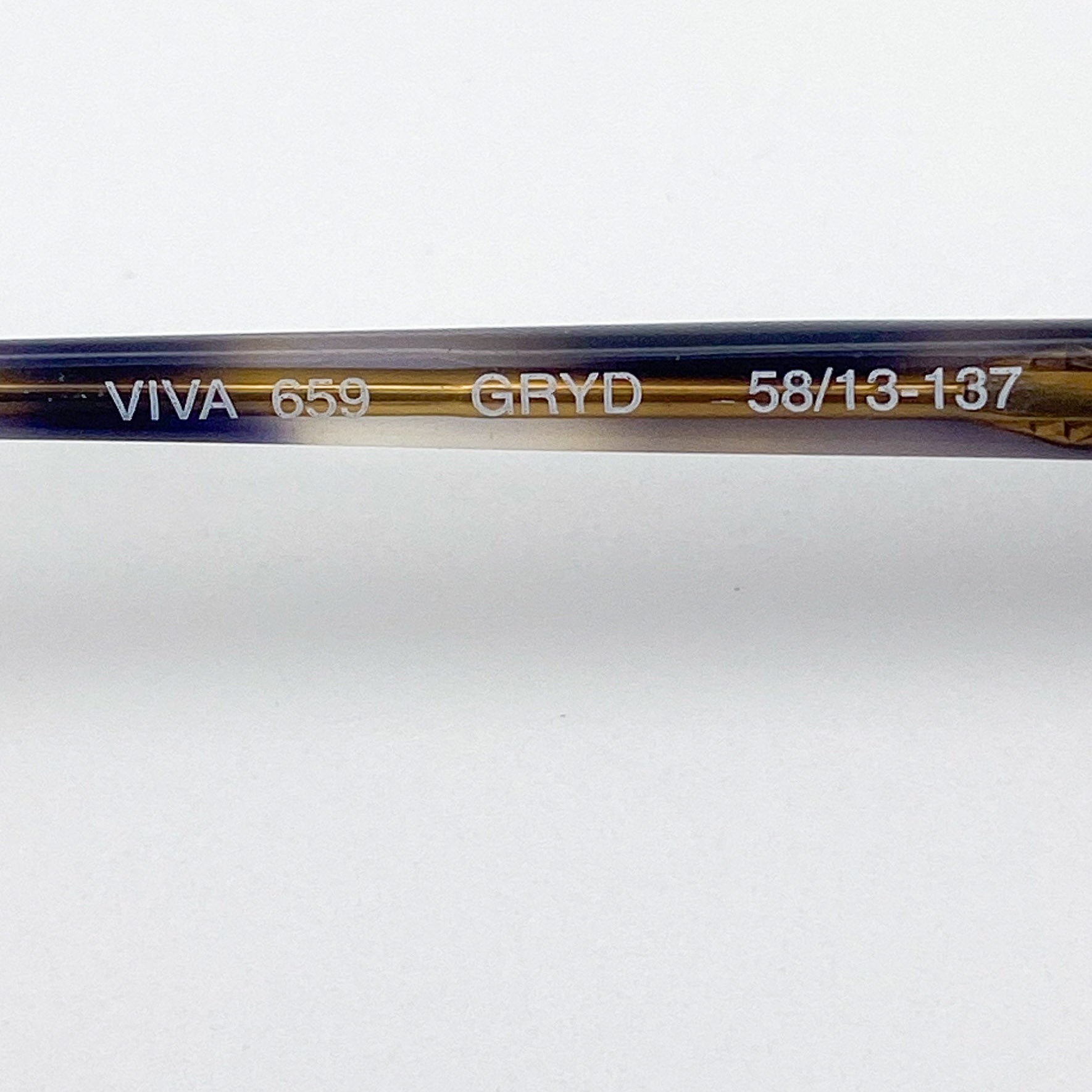 Close-up of an eyeglass stem with branding and model information on a white background